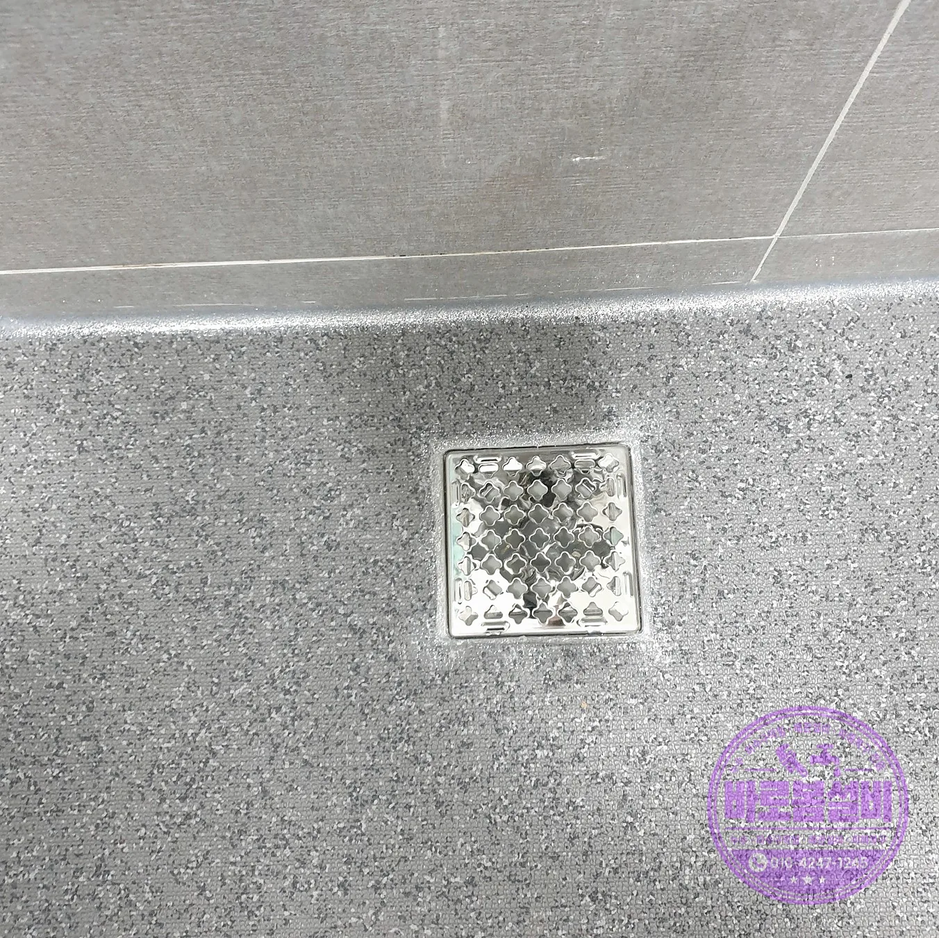 욕실 바닥 타일 위의 배수구 덮개